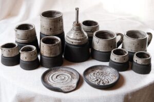 Ariadna Alvarez: A collection of hand-thrown and hand-built stoneware pieces, exploring contrast through raw, textured clay bodies and softly speckled glazes. Each form is intentionally imperfect, celebrating tactility, balance, and the quiet beauty of functional objects made to be lived with.