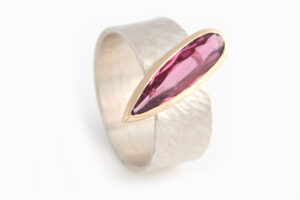 Emily Fermor: Pink Tourmaline long drop set in 18ct rose gold ontop of a silver 'rays' texture band